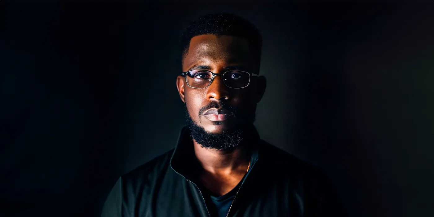 Portrait de Ndiaga, directeur artistique de SIX1 CREATIVE, éclairé de face sur fond sombre